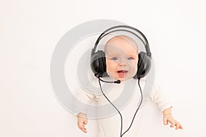 Portrait of a child on a white background with headphones. stay home, coronavirus 19. Baby 6 months listening to music. Space for