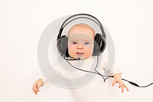 Portrait of a child on a white background with headphones. stay home, coronavirus 19. Baby 6 months listening to music. Space for