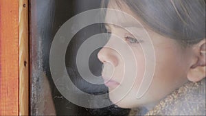 Portrait of child in the window. The boy face close up child through the glass.