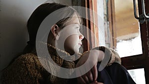 Portrait of child in the window. The boy face close up child through the glass.