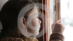 Portrait of child in the window. The boy face close up child through the glass.