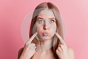 Portrait of childish cute lady inflate cheeks press fingers fooling around on pink background