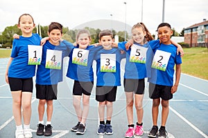 Portrait Of Children On Athletics Track Wearing Competitor Numbers On Sports Day