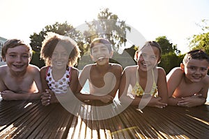 Portrait Of Children Having Fun In Outdoor Swimming Pool