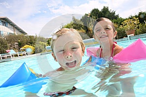 Portrait of children having fun in swimming pool