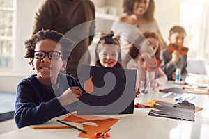 Portrait Of Children At Home With Parents Having Fun Making Craft Together