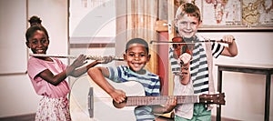 Portrait of children playing musical instruments in classroom