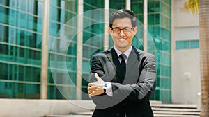 Portrait Chinese Businessman With Arms Crossed Smiling Outside O photo