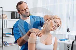 portrait of chiropractor stretching neck of woman