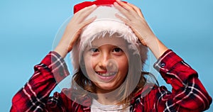 Portrait of Christmas little Girl in Santa Hat, joyful, smiling child