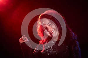 Portrait of chubby teen girl illuminated by red light and black background