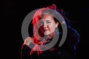 Portrait of chubby teen girl illuminated by red light and black background