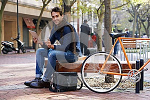 Portrait, city and smile with man, tablet and bicycle with adventure and travel with internet and social media. Person