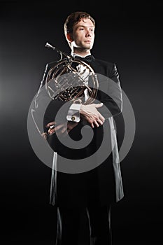 Portrait of classical musician with french horn