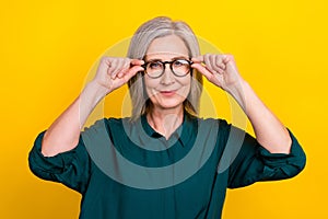 Portrait of clever cheerful aged lady agent hands touch glasses isolated on yellow color background