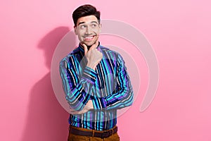 Portrait of clever cheerful young man arm touch chin look empty space contemplate  on pink color background