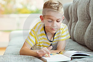 Portrait of clever little boy with reading book