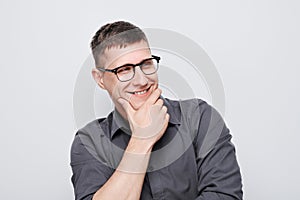 Portrait of clever man in shirt touching chin thinks doubts chooses isolated on white studio background