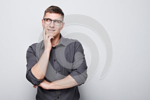 Portrait of clever man in shirt touching chin thinks doubts chooses isolated on white studio background