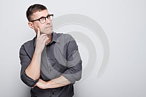 Portrait of clever man in shirt touching chin thinks doubts chooses isolated on white studio background