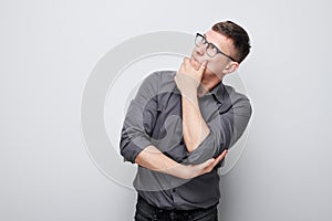 Portrait of clever man in shirt touching chin thinks doubts chooses isolated on white studio background