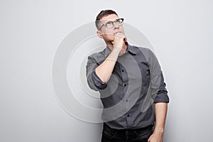 Portrait of clever man in shirt touching chin thinks doubts chooses isolated on white studio background