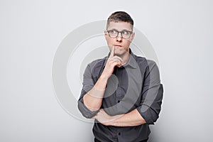 Portrait of clever man in shirt touching chin thinks doubts chooses isolated on white studio background