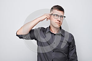 Portrait of clever man in shirt touching head thinks doubts chooses isolated on white studio background