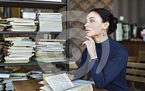 Portrait of clever student in university library.
