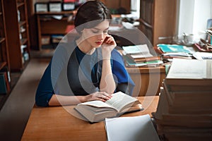 Portrait of clever student in university library.