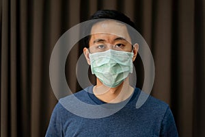 Portrait close-up of Asian man wearing a protective face mask against contagious disease and coronavirus.