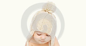 Portrait close up of baby wearing winter knitted hat over a white background