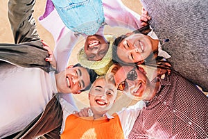 Portrait close up bottom view happy faces of diverse friends standing in circle, looking at camera,. down view photo photo