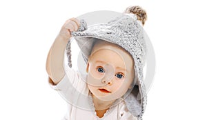 Portrait close up of cute baby wearing winter knitted gray hat over a white background