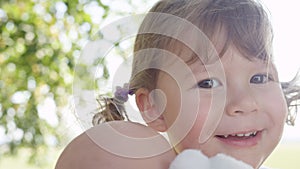 CLOSE UP, DOF: Lovely baby girl with cute pigtails plays with her toy doll.