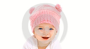 Portrait close-up face happy smiling baby in knitted pink hat on white