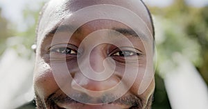 Portrait close up of happy african american groom smiling at wedding in sunny garden, in slow motion