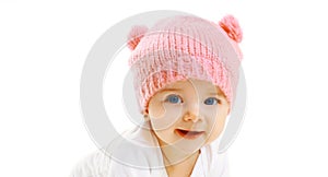 Portrait close-up happy smiling baby in knitted pink hat on white