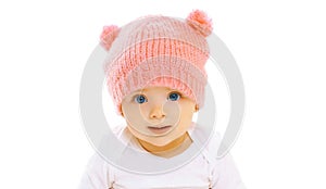 Portrait close-up happy smiling baby in knitted pink hat on white
