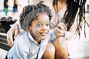 Portrait close up of little guy enjoying time outdor with his mommy. Family with black mother and son in outdoors leisure activity