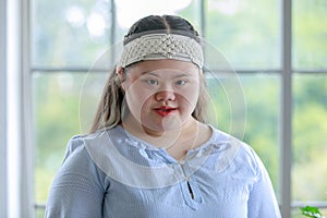 Portrait close up shot of Asian young happy chubby down syndrome autistic autism girl model wearing white knitted headband