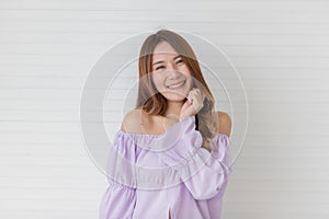Portrait close up shot of young pretty asian female with long brown hair wearing light purple long sleeve shirt stand smiling to