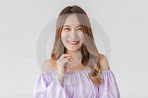 Portrait close up shot of young pretty asian female with long brown hair wearing light purple long sleeve shirt stand smiling to