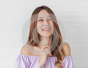 Portrait close up shot of young pretty asian female with long brown hair wearing light purple long sleeve shirt stand smiling to