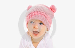 Portrait close up of sweet baby wearing knitted pink hat over a white background