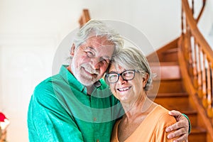 Portrait and close up of two happy seniors or mature and old people smiling and looking at the camera - couple of pensioners