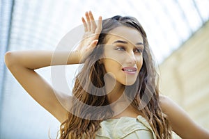 Portrait close up of young beautiful brunette woman in beige dress