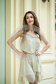 Portrait close up of young beautiful brunette woman in beige dress