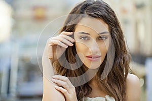 Portrait close up of young beautiful brunette woman in beige dress