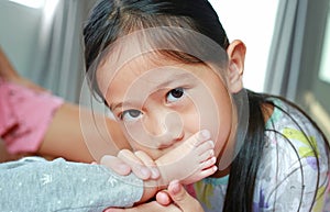 Portrait closeup of asian little child girl smelling her sister foot